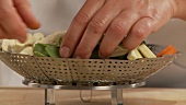 Prepared vegetables being placed in a steamer