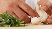 Garlic being peeled and halved