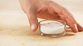 A bowl of salt being picked up