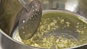 Olive oil being heated in a pot and garlic being fried