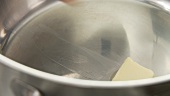 Ein Stück Butter in einem Topf schmelzen lassen