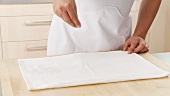 A clean, dry cloth being sprinkled with sugar