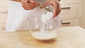 Icing sugar and whipped cream stabilzer being added to cream and whipped