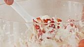 Strawberries being mixed with cream