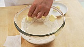 Butter pieces being placed around the starter dough