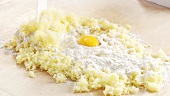 Gekochte Kartoffelmasse mit Mehl und Ei vermischen
