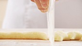Gnocchi being cut with a dough scraper