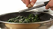 Steamed spinach being seasoned