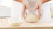 Pizza dough being kneaded and placed in a bowl