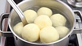 Finished potato dumplings being removed from the water