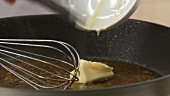 A piece of butter being stirred into gravy