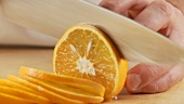 Eine Orange in Scheiben schneiden