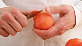 A tomato being peeled