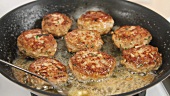 Butter being added to frying burgers
