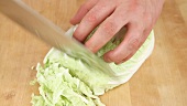 Chinese cabbage being cut into fine strips