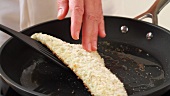 Breaded haddock being fried in a pan