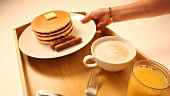 Orangensaft einschenken & Pancake mit Ahornsirup übergiessen
