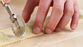 Ravioli being cut out with a dough wheel