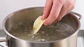 Ravioli being placed into a pot of boiling water