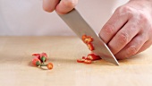 A chilli pepper being cut into rings
