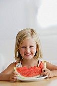 Little girl with slice of water melon with a bite missing