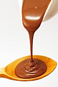 Melted chocolate running on to wooden spoon