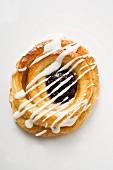 A Danish pastry with jam and white icing