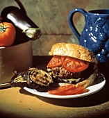 A Hamburger with Sliced Tomato; Grilled Eggplant