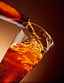 Bier wird aus Flasche in Glas gegossen