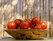 Tomaten in einer Tonschale auf Holztisch