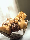 Brotkorb mit hellen Broten, Brötchen & dunklem Rosinenbrot