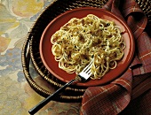 Spaghetti with caramelised onions on a red plate