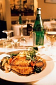 Fisch mit Gemüse auf Teller am Tisch eines Restaurants
