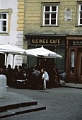 Menschen sitzen an Tischen vor Café (Kleines Café in Wien)