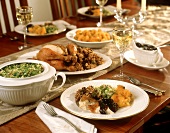Gedeckter Tisch mit gefülltem Brathähnchen, Salat & Wein
