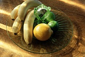 Bananen, Orange & Limetten auf Glasteller