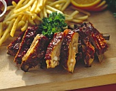 Spareribs mit Pommes frites auf Schneidebrett