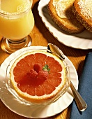Pink Grapefruit Half in a Bowl; Juice and Toast