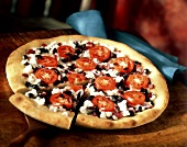 Griechische Pizza mit Schafskäse, Oliven und Tomaten