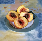 Two Peaches Cut in Half on a Plate