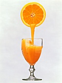 Orange Juice Pouring From an Orange into a Glass