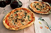 Zwei Pizzen auf Tisch in einem Restaurant; Rotwein