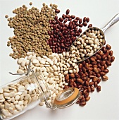 Assorted Beans Spilling From a Jar; Metal Scoop