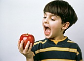 Kleiner Junge will in einen Red Delicious Apfel beissen