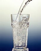 Wasser in ein Glas einschenken