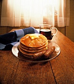 Pancakes mit Ahornsirup und Bratwürstchen