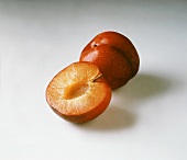 Plums; One Halved with Pit Removed