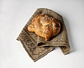 Poppy seed pretzel with salt on embroidered cloth