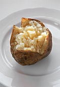 Eine gebackene Kartoffel mit Butter auf Teller