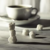 weiße Zuckerwürfel vor Kaffeetasse